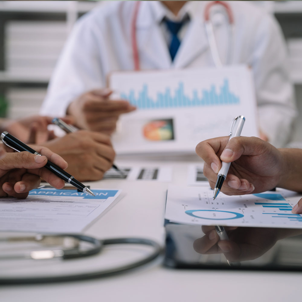 healthcare team at a table looking over predictive analytics report and outcome assessment
